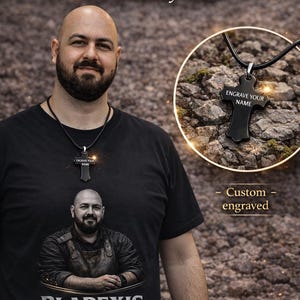 May include: A black engraved locket with the text "ENGRAVE YOUR NAME" is shown in this image. The locket is on a black cord. The image also features a man wearing a black t-shirt with the text "BLADEXIS FORGE". The text "FREE ENGRAVED LOCKET With Every Order" is also visible.
