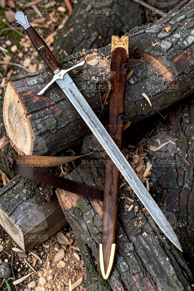 May include: A long, ornate sword with a patterned blade and a wooden handle, resting on a wooden log. The sword has a silver crossguard and a brown leather sheath with gold accents. The blade has a unique pattern.