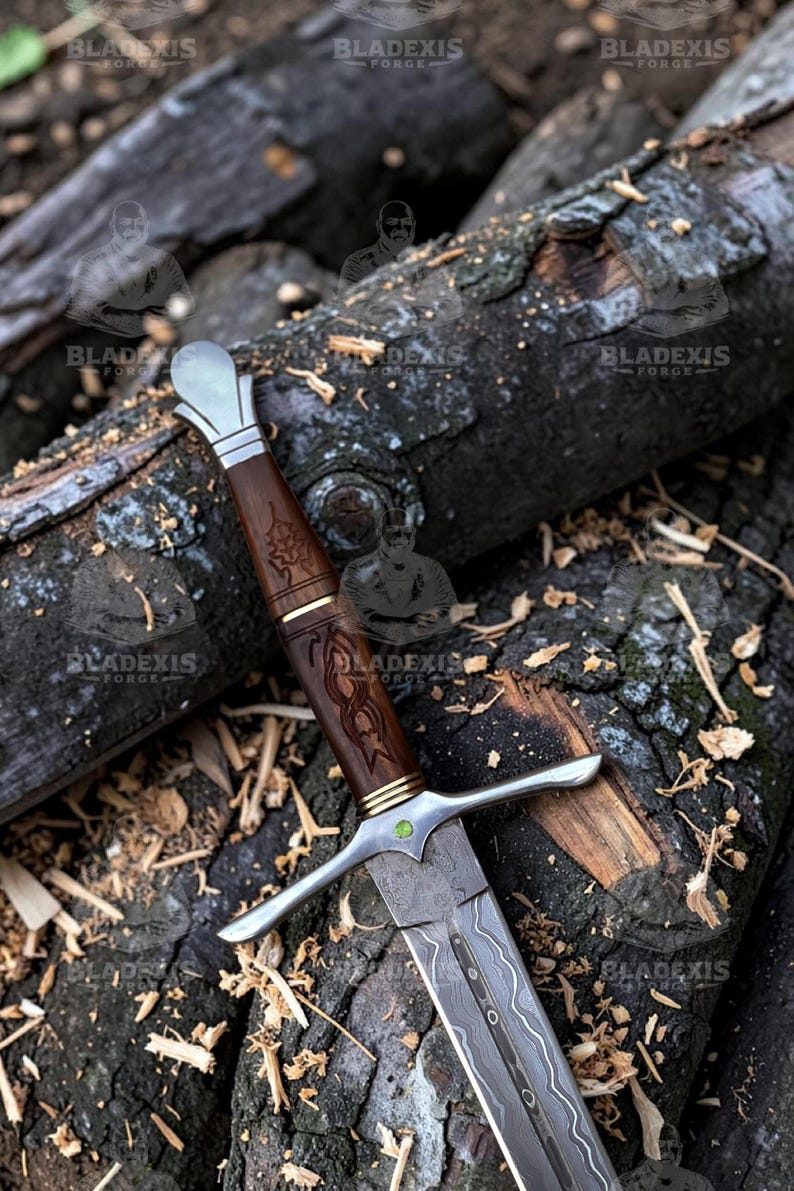 May include: A detailed image of a sword with a wooden handle and a silver blade. The handle is intricately carved with a dark brown finish, and the blade has a patterned design. The sword rests on a bed of weathered logs, showcasing a rustic aesthetic.