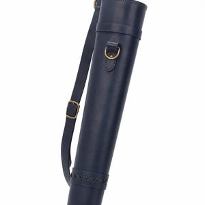 May include: A dark blue leather quiver featuring a cylindrical body, an adjustable shoulder strap with a brass buckle, and a decorative braided leather band near the base. The design includes brass D-rings for attachment and reinforced stitching.