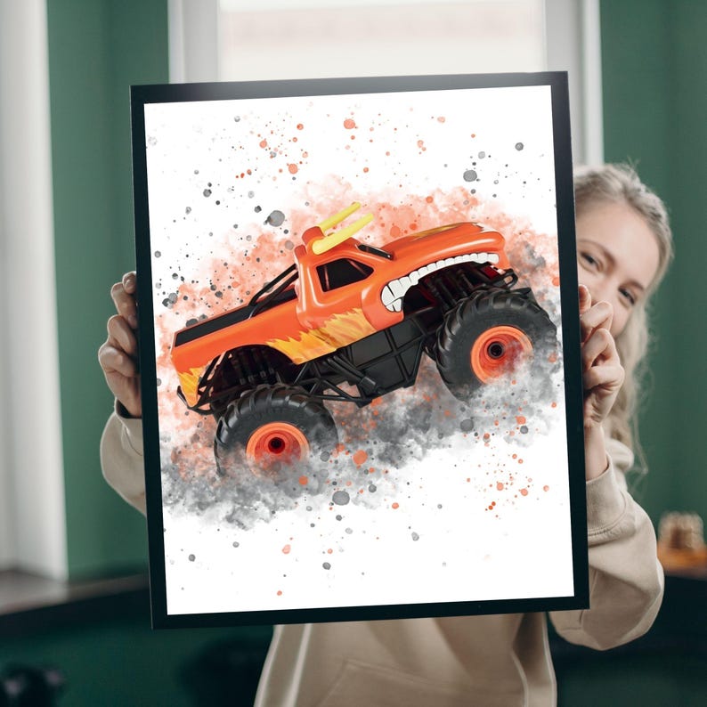 May include: Framed illustration of an orange monster truck. The truck has large black wheels with orange details and a cartoon face. The background features orange and grey paint splatters, creating a dynamic effect.