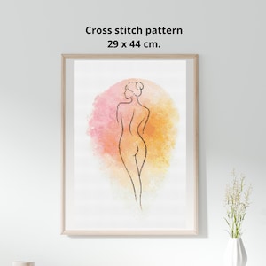 Può includere: Schema a punto croce incorniciato con un disegno a tratto minimalista della silhouette di una donna. L'opera è ambientata su uno sfondo ad acquerello con sfumature rosa e gialle. La cornice misura 29 x 44 cm.