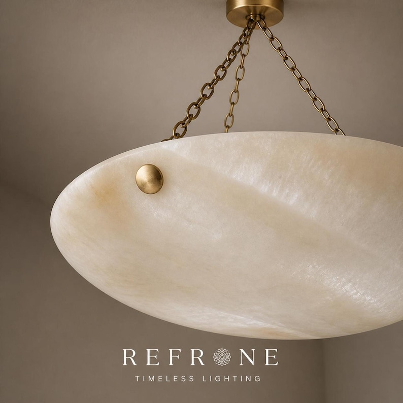 Close side detail of alabaster bowl pendant rim, natural stone veins and a brass rivet accent on the shade