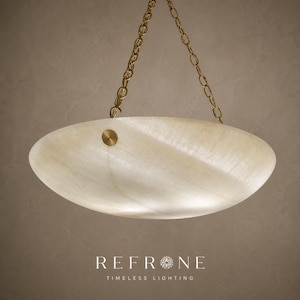 Centered view of shallow alabaster bowl pendant, warm internal glow, polished brass fittings and chain