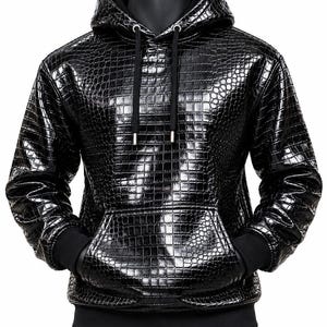 Peut inclure: Un sweat à capuche noir doté d'un motif texturé en peau de crocodile brillant. Le vêtement comprend une capuche avec des cordons noirs, des manches longues à poignets côtelés et une poche kangourou. L'ourlet est fini par une bande côtelée noire.