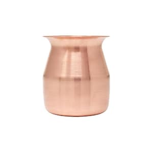 Könnte beinhalten: Eine kupferfarbene Vase mit einem breiten, leicht ausgestellten Rand und einem abgerundeten Körper. Die Metalloberfläche hat eine gebürstete Textur, die das Licht reflektiert und einen warmen, metallischen Glanz erzeugt. Die Vase hat eine schlichte, elegante Form.