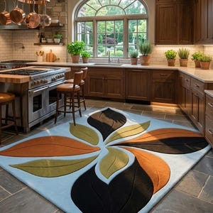 Può includere: Un tappeto rettangolare con sfondo azzurro e un grande motivo centrale ispirato ai fiori, composto da forme di foglie sovrapposte nei toni del nero, arancione bruciato e verde oliva, creando un design audace e simmetrico.