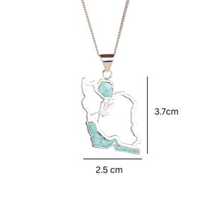 May include: A silver-colored necklace with a pendant shaped like the outline of a country, filled with turquoise-colored stone. The pendant is 2.5 cm wide and 3.7 cm tall. The necklace is on a white background.