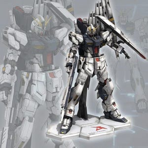Può includere: Modello dettagliato di un robot mecha bianco, nero e rosso con un grande scudo e un fucile. Il robot è in piedi su una base esagonale con un logo. Un'immagine sbiadita del robot è sullo sfondo.