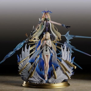 Puede incluir: Figura detallada con dos figuras femeninas con cabello rubio suelto y atuendos elaborados. La base está adornada con detalles dorados, alas azules y espadas estilizadas. La figura superior tiene los brazos extendidos, mientras que la figura inferior tiene las manos juntas en oración.