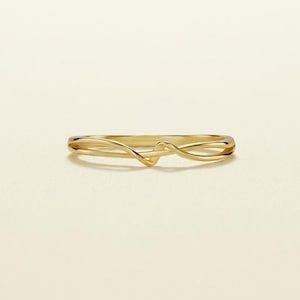 May include: A polished yellow gold ring featuring a slender, continuous band that curves and overlaps at the centre to create a delicate, fluid, and interconnected wave-like design. The metal surface is smooth and reflective throughout the piece.