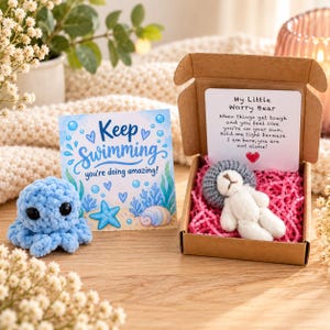 May include: A light blue crocheted octopus, a card with the text Keep Swimming you're doing amazing, and a brown cardboard box containing a small white bear with a gray hat and a card with the text My Little Worry Bear.