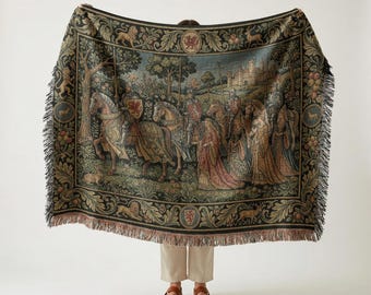 May include: A woven throw blanket featuring a medieval scene with knights on horseback and figures in long robes. The design includes a dark decorative border with lions, deer, and fruit motifs, finished with a fringed edge on all sides.