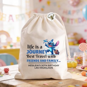 Może przedstawiać: Beżowa torba ze sznurkiem z niebieską postacią z kresk&oacute;wki z walizką i samolotem. Tekst na torbie brzmi "life is a JOURNEY Best Travel with FRIENDS AND FAMILY..." i "HESILEIN'S 30TH BIRTHDAY LAS VEGAS, 2026". Dołączona jest naklejka Bumble Bee.