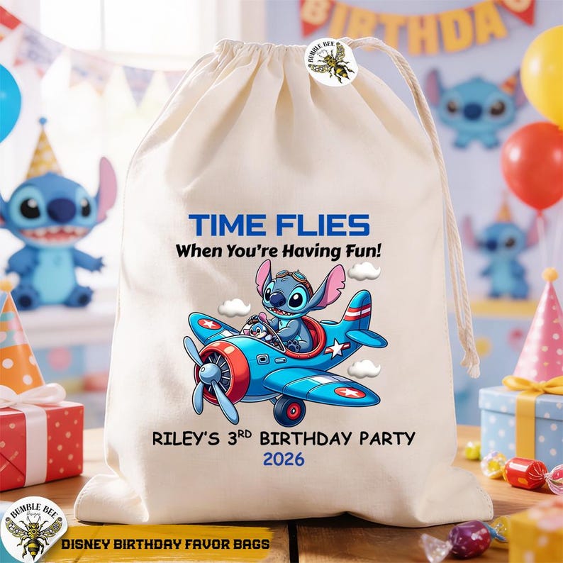 May include: A cream-colored drawstring bag with a blue and red airplane graphic featuring a cartoon character. The text on the bag reads "TIME FLIES When You're Having Fun!" and "RILEY'S 3RD BIRTHDAY PARTY 2026". The bag is labeled "DISNEY BIRTHDAY FAVOR BAGS".