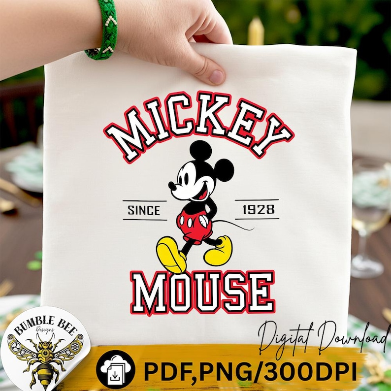 May include: A white tote bag featuring a classic Mickey Mouse design. The design includes the words "Mickey Mouse" in red and white, with Mickey Mouse in his iconic outfit. The text "Since 1928" is also included.