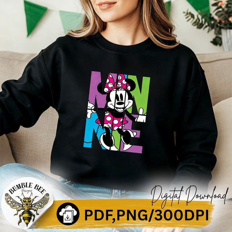 May include: Black sweatshirt featuring a colorful graphic of Minnie Mouse with the word "MINNIE" in bold letters. Minnie Mouse is wearing a pink polka dot dress and bow. The sweatshirt has a crew neck.