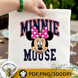 May include: A white tote bag featuring a Minnie Mouse graphic. The design includes the word "MINNIE" in navy blue and red lettering above Minnie's face, and the word "MOUSE" below. Minnie Mouse has a pink polka dot bow.