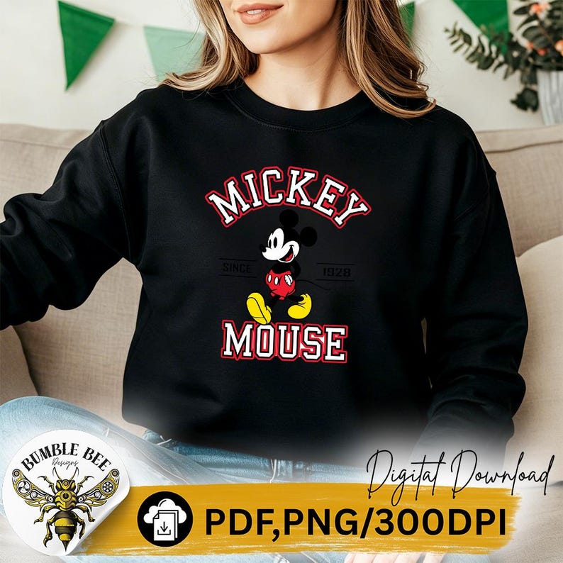 May include: Black sweatshirt featuring a Mickey Mouse graphic. The design includes the words "MICKEY MOUSE" in red and white, with "SINCE 1928" below. The sweatshirt also has a Bumble Bee Designs logo and text that says "Digital Download PDF, PNG/300DPI".