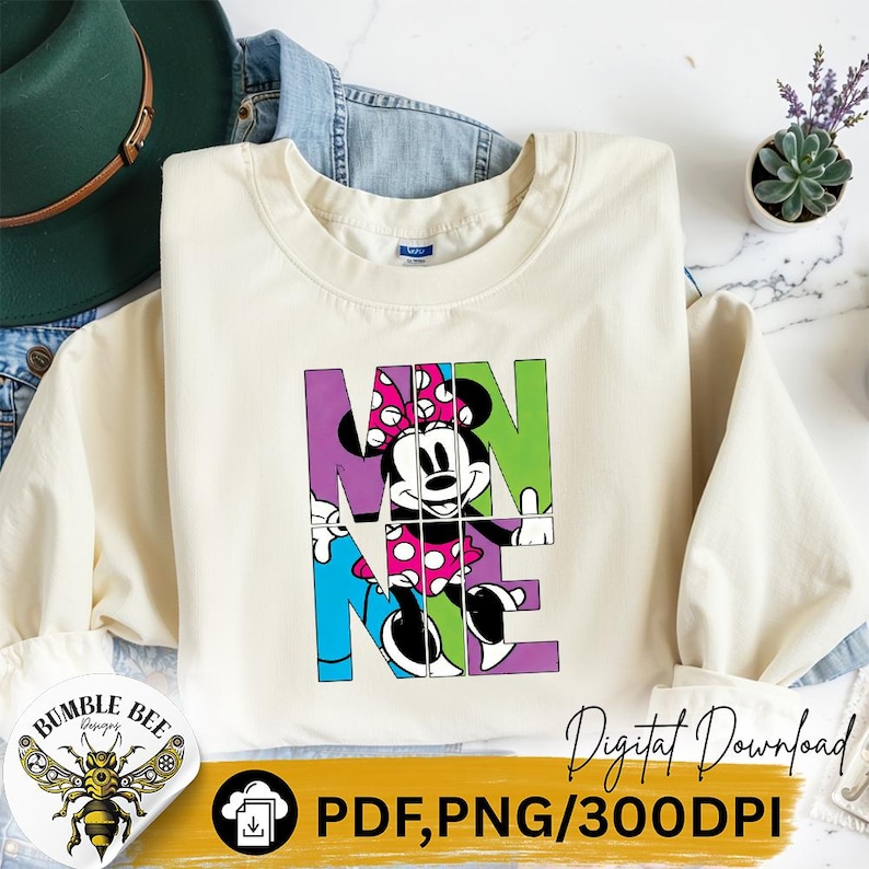 May include: Cream-colored sweatshirt featuring a colorful graphic of Minnie Mouse integrated into the word "MINNIE". The design includes a pink polka-dot bow and is set against a backdrop of purple, green, and blue blocks. The image also includes the text "Digital Download".
