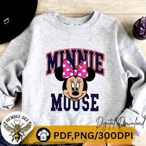 May include: A light gray sweatshirt featuring a graphic of Minnie Mouse with a pink polka dot bow. The word "MINNIE" is above the character's head in a navy blue and red collegiate font, and "MOOSE" is below. The image also includes the text "Digital Download".