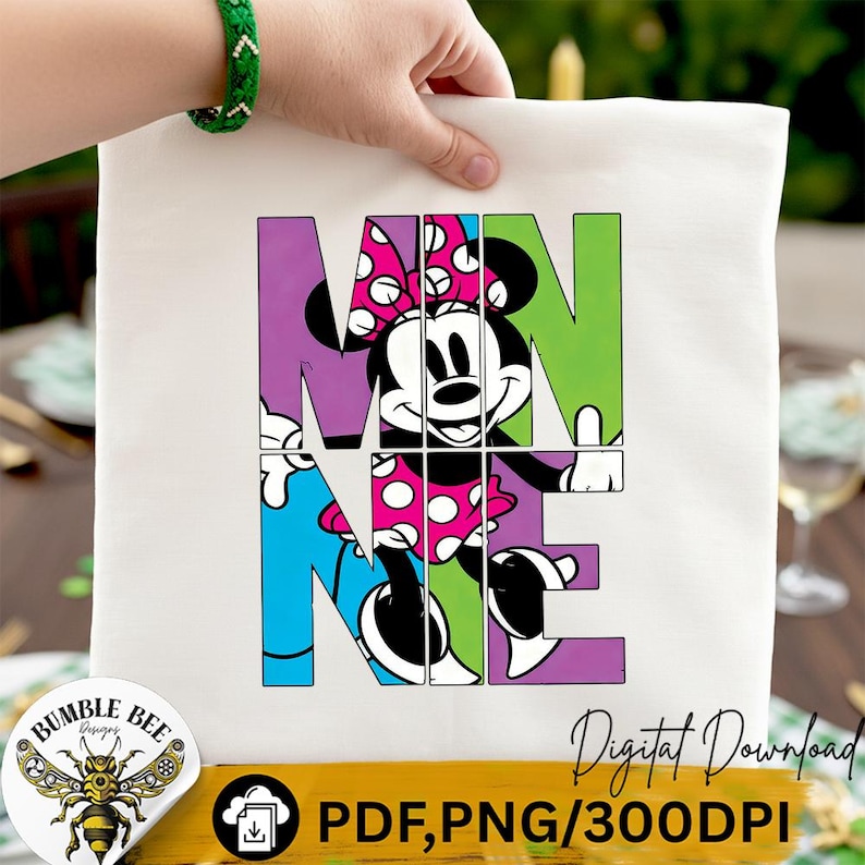 May include: A white tote bag featuring a colorful graphic of Minnie Mouse. The word "MINNIE" is spelled out in large, block letters, with Minnie Mouse's image integrated into the design. The bag is held by a hand wearing a green bracelet.
