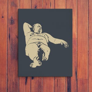 Könnte beinhalten: Leinwanddruck mit einer beigen Illustration einer liegenden Figur vor einem dunkelgrauen Hintergrund. Das Kunstwerk ist in einem schwarzen Rahmen auf einem Holzgrund montiert.