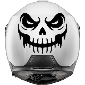 Pode incluir: Capacete de motocicleta branco com um design de rosto de caveira preta. A caveira tem olhos ameaçadores e uma boca irregular. O capacete é do estilo integral, com uma viseira escura e protetor de queixo.