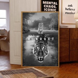 May include: Black and white framed art print featuring a cat above a tiger reflection in water. The word "MINDSET" is printed across the water. Two other framed prints are visible, one with the text "MENTAL CHAOS. ICONIC" and the other with "ask believe receive".