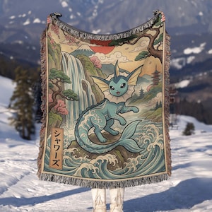 May include: A woven throw blanket featuring a blue Vaporeon character standing on a rock amidst stylized ocean waves, a waterfall, cherry blossoms, and a mountain landscape. The design includes a vertical rectangular box with the Japanese text シャワーズ.