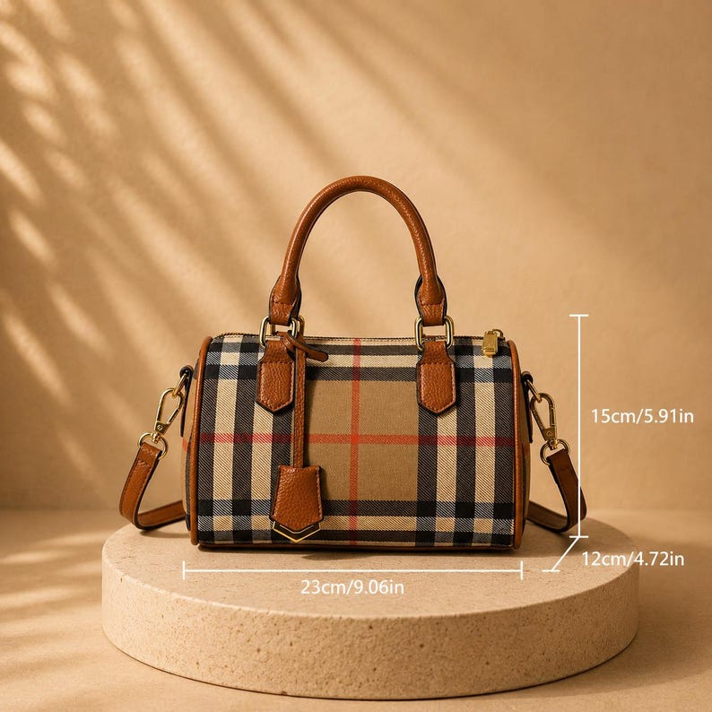 Puede incluir: Bolso de mano a cuadros marr&oacute;n y beige con asa superior y bandolera extra&iacute;ble. El bolso mide 23 cm de largo, 15 cm de alto y 12 cm de ancho. Tiene detalles en cuero marr&oacute;n y una peque&ntilde;a etiqueta a juego.