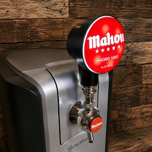 May include: A silver and black beer dispenser with a tap and a red and white Mahou logo. The dispenser has a digital display and the text "PerfectDraft". The tap handle has a small red Mahou logo.