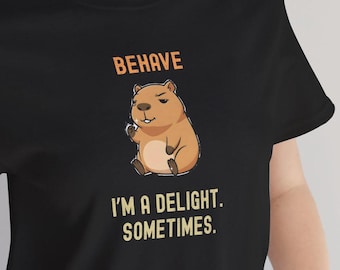 Camiseta engraçada de capivara, com a frase "Comporte-se, sou uma delícia" e um toque sarcástico e kawaii.