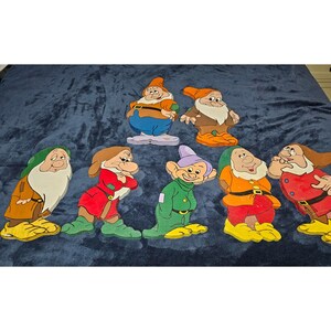 May include: A set of seven wooden cutouts depicting cartoon characters with distinct facial expressions and colourful clothing, including hats, tunics, and belts. Each figure is rendered in a flat, illustrative style with bold outlines and vibrant paint.