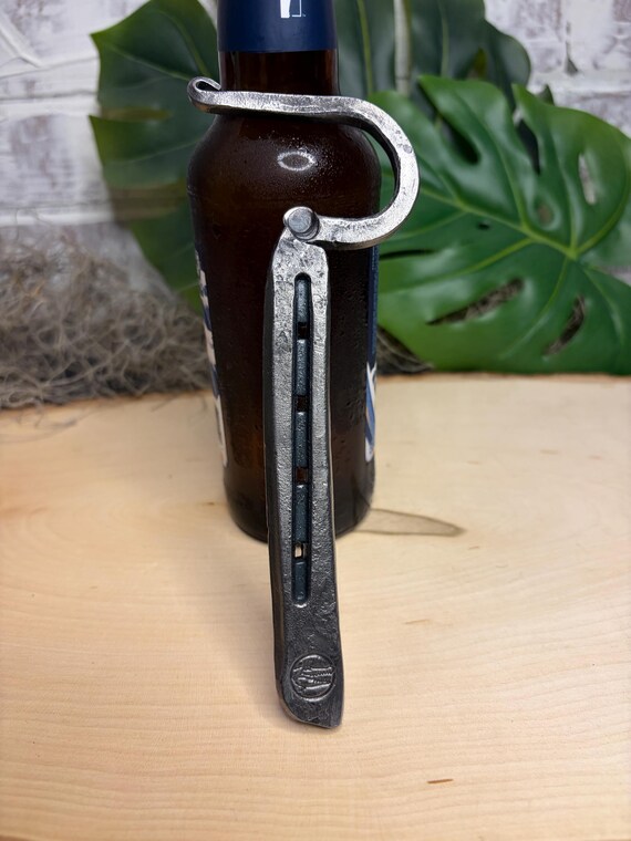 An actual horseshoe bent and finished into a bottle opener — rustic Americana form-meets-function that looks great mounted on a barn bar.