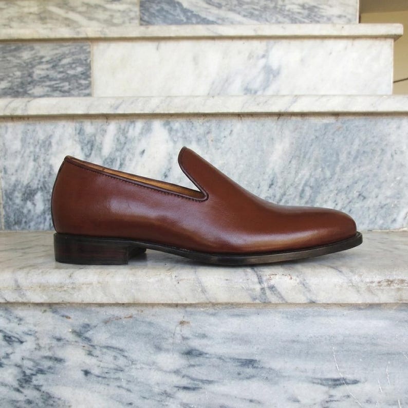 Side profile of handmade Venetian loafer for men showing clean single piece leather upper and block heel