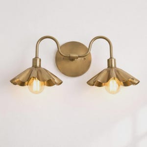 Elegant vintage brass double sconce brightens mirror areas beautifully

Scalloped metal shades create warm farmhouse ambience

Perfect vanity lighting for bathrooms hallways bedrooms

Stylish gold fixture supports glowing edison bulbs

Durable craftsmanship delivers timeless decorative interior accent