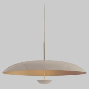May include: A pendant light fixture featuring a wide, shallow, dome-shaped shade in a glossy off-white finish. The shade is suspended by a thin, vertical brass-toned metal rod that extends through the center, ending in a small, matching cap.
