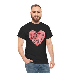 Puede incluir: Camiseta negra con un corazón rojo estilo acuarela y la frase "Up loving, Love, Boy!" en escritura negra. Una camiseta de estilo casual, adecuada para el uso diario.