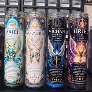 May include: Four tall cylindrical glass candles featuring colorful illustrations of Archangels Ariel, Sandalphon, Michael, and Uriel. Each candle displays specific angelic names, attributes, and printed prayers with moon phase icons at the base.