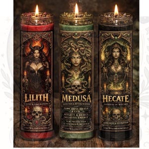 Op de afbeelding: Drie brandende pilaar kaarsen met gedetailleerde etiketten. De etiketten bevatten illustraties van Lilith, Medusa en Hecate, met tekst als "Lust & Liberation", "Turn Away Hexes & Evil" en "Darkness & Divination". Elke kaars heeft een uniek kleurenschema.