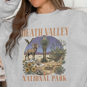 May include: A white-painted wooden 'Welcome' sign with a distressed finish and a floral design in pink and green. The sign, suitable for indoor or outdoor use, features the word 'Welcome' in a decorative font. It is a handmade item.