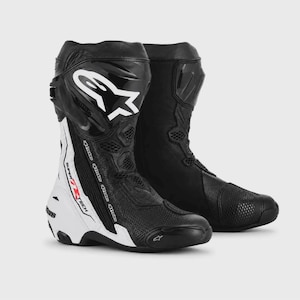Puede incluir: Un par de botas de carreras para motocicleta en color negro y blanco con el logotipo de Alpinestars en la espinillera. Las botas tienen una parte superior de malla texturizada, un talón rígido y el texto Supertech impreso en rojo y negro.