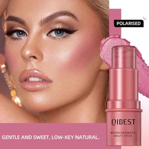 May include: A woman with makeup, including blush, is shown next to a pink monochromatic multi-stick. The stick is labeled "QIBEST" and "MONOCHROMATIC MULTI-STICK." The text "POLARISED" is also visible. The bottom of the image reads "GENTLE AND SWEET, LOW-KEY NATURAL."