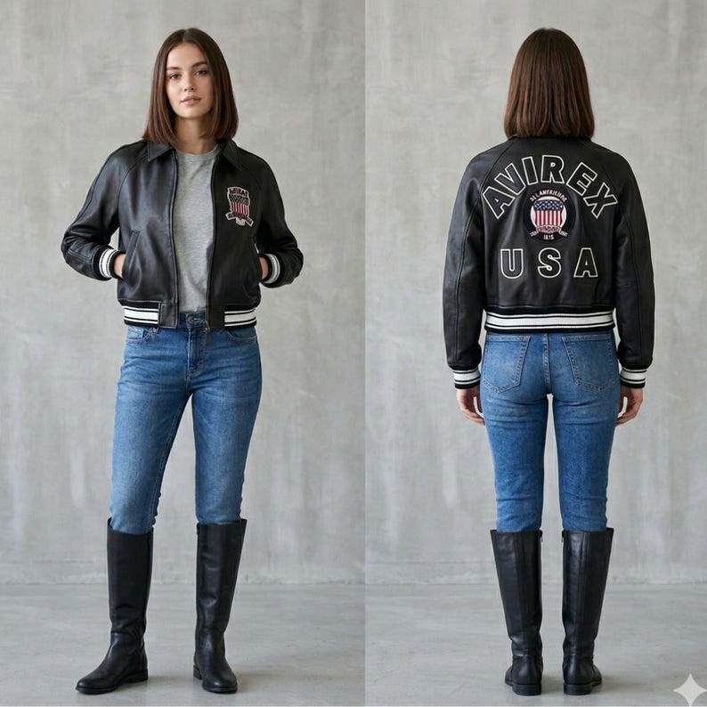 Puede incluir: Chaqueta de cuero negra con ribetes a rayas blancas y negras, con un parche en el pecho y el texto "AVIREX USA" en la espalda. La chaqueta se combina con vaqueros azules y botas altas negras.