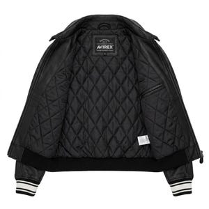 Puede incluir: Chaqueta de cuero negra con interior acolchado. La chaqueta presenta un cuello cl&aacute;sico, cierre de cremallera y pu&ntilde;os acanalados con rayas blancas. El forro interior es negro y acolchado con rombos. La etiqueta de la marca "AVIREX" es visible.