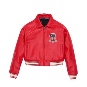 Puede incluir: Chaqueta de cuero roja brillante de estilo bomber cl&aacute;sico. Cuenta con cremallera frontal, cuello y un parche en el pecho con un emblema. Los pu&ntilde;os y el dobladillo tienen detalles de rayas blancas y rojas. Una prenda de abrigo elegante.