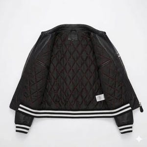 May include: Black leather jacket with a quilted, burgundy-lined interior. The jacket features a zipper closure, two front pockets, and white stripes on the cuffs and hem. A classic outerwear piece.