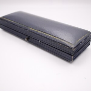 Closed view of the vintage navy blue Perry Greaves Birmingham watch box, showing its textured exterior.