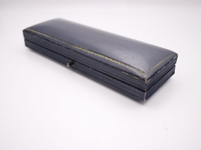 Closed view of the vintage navy blue Perry Greaves Birmingham watch box, showing its textured exterior.